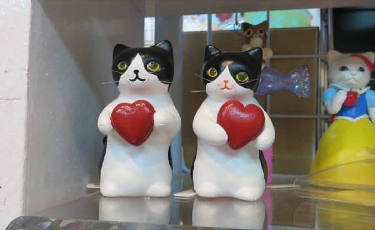 A cat figurine holding a heart