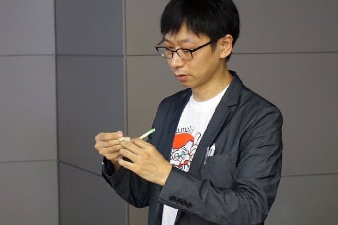 Mr. Takahata, who makes an airplane with sticky notes, is wearing a 3M character, not a funny T-shirt.
