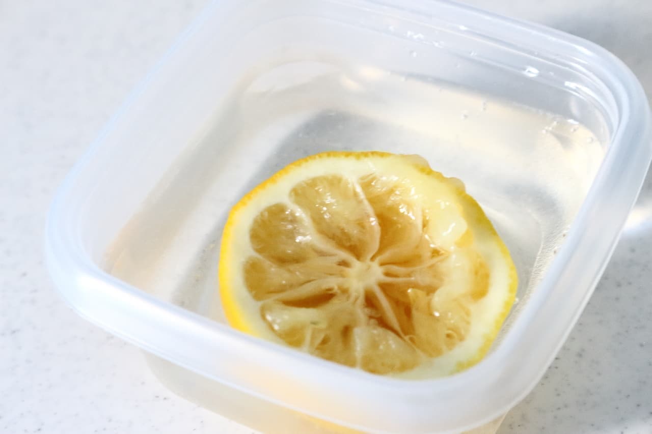 ステップ1、果汁を絞った後のレモンを耐熱容器に入れ、ひたひたになるくらいの水を加えます。