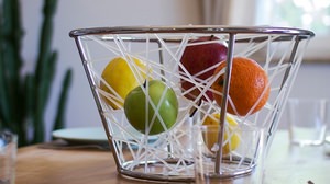 フルーツを“宙に浮かせて”ディスプレイするバスケット「Elastic Fruit Basket」